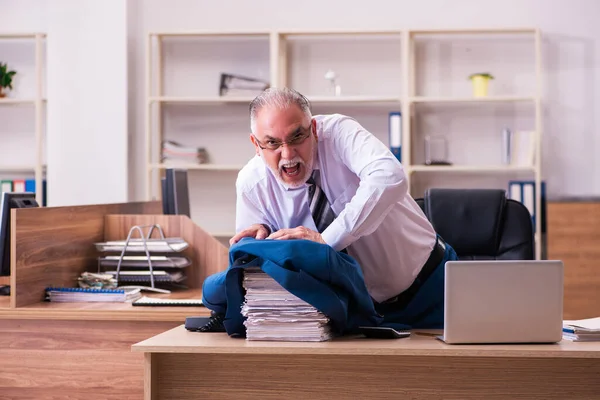 Ένας ηλικιωμένος εργάτης δυσαρεστημένος με την υπερβολική δουλειά στο γραφείο. — Φωτογραφία Αρχείου