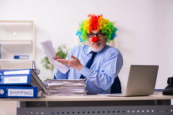 Old businessman clown working in the office