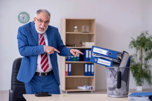 Oude zakenman werknemer verwerpt nieuwe ideeën met veel papieren — Stockfoto