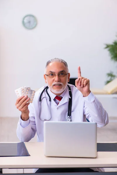 Velho médico segurando pílulas — Fotografia de Stock