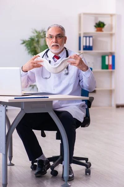 Viejo médico sosteniendo cuello de cuello — Foto de Stock