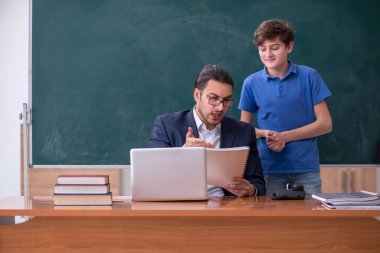 Genç erkek öğretmen ve okul çocuğu sınıfta.