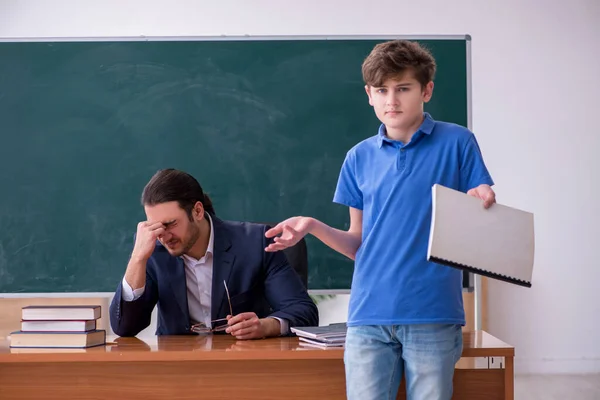 Jeune enseignant et écolier dans la salle de classe — Photo