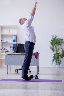 Mola sırasında fiziksel egzersiz yapan yaşlı bir erkek.