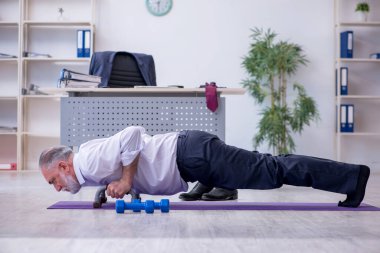 Mola sırasında fiziksel egzersiz yapan yaşlı bir erkek.