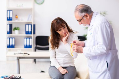 Genç kadın yaşlı erkek doktor göz doktorunu ziyaret ediyor.