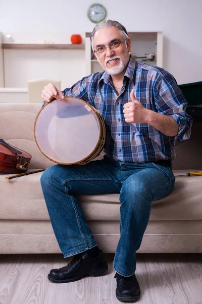 Hombre mayor reparador reparando instrumentos musicales en casa —  Fotos de Stock