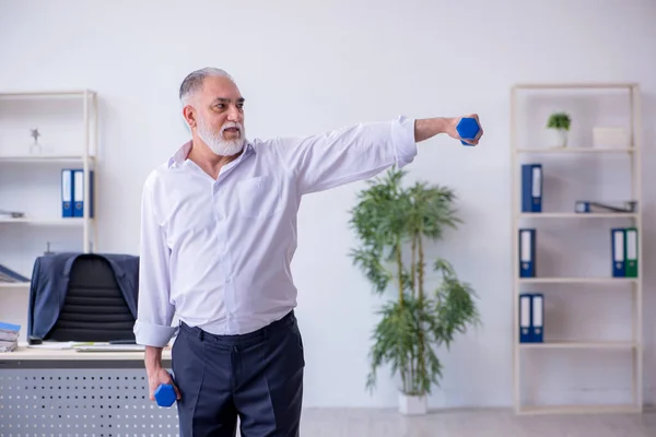 Мужчина в возрасте делает физические упражнения во время перерыва — стоковое фото