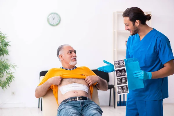 Alt mann besuch jung männlich doktor — Stockfoto