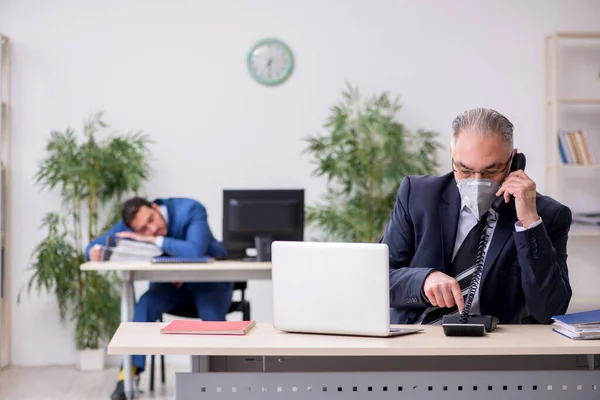 Due dipendenti sul posto di lavoro durante la pandemia — Foto Stock