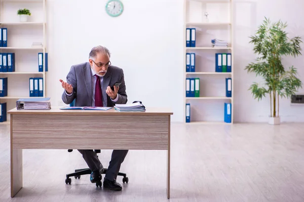 Ervaren mannelijke werknemer werkzaam in het kantoor — Stockfoto