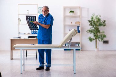 Hastanede çalışan yaşlı doktor radyoloji uzmanı.