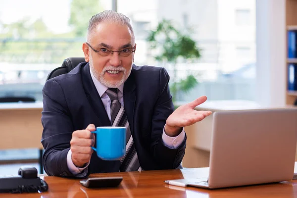 Ein alter Geschäftsmann arbeitet im Büro — Stockfoto