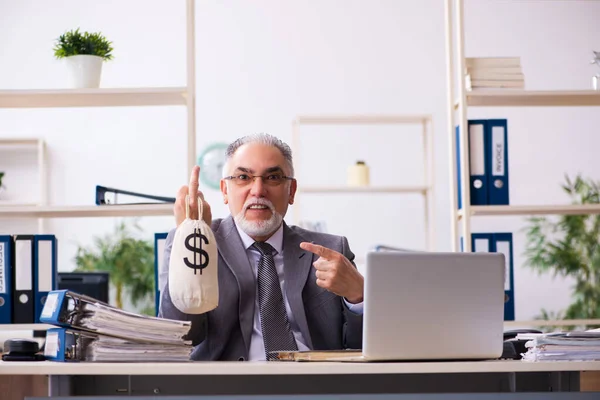 Gammal manlig anställd som håller pengar i pension koncept — Stockfoto