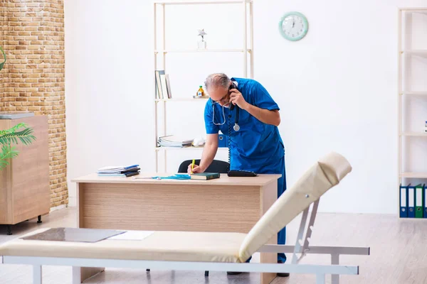 Vieux médecin masculin travaillant à la clinique — Photo