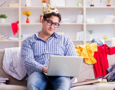 Dağınık odada çalışan genç adam.