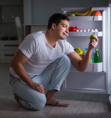 Buzdolabındaki adam gece yemek yiyor.
