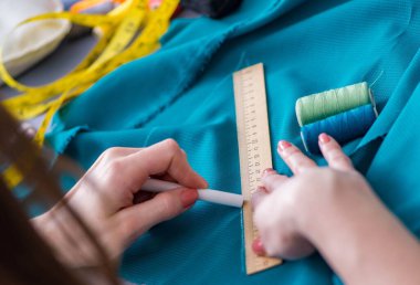 Kadın terzi dikiş dikmek için dikiş dikiyor.