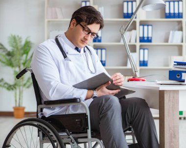 Hastanede çalışan tekerlekli sandalyedeki engelli doktor.