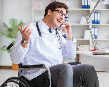 Hastanede çalışan tekerlekli sandalyedeki engelli doktor.