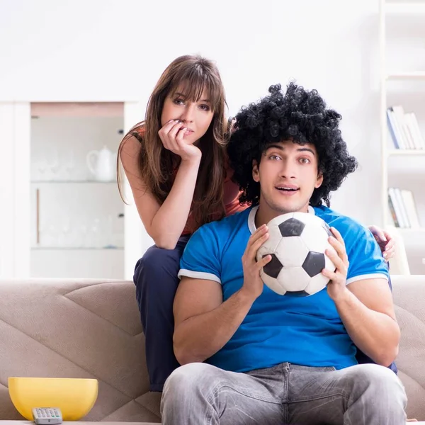 Joven hombre viendo fútbol con su esposa en casa —  Fotos de Stock