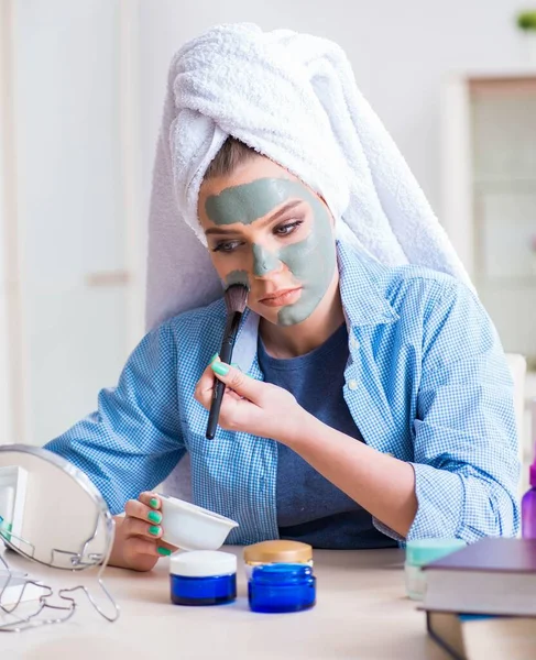 Frau trägt Tonmaske zu Hause mit Pinsel auf — Stockfoto