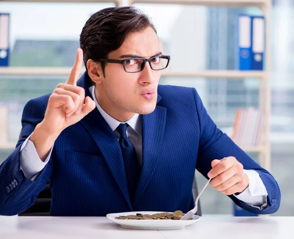 Grappige zakenman eet gouden munten op kantoor — Stockfoto