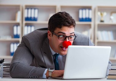 Ofiste çalışan palyaço işadamı.