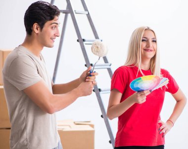 Ev tadilatı sırasında genç bir aile boya işi yapıyor.