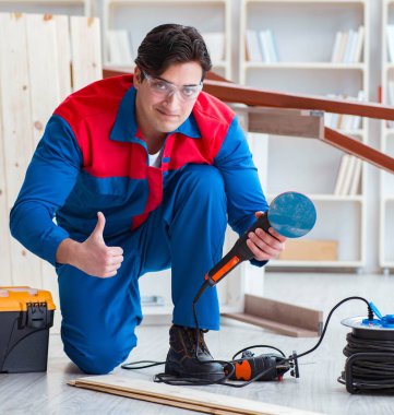 Genç marangoz ahşap kalaslarla çalışıyor.