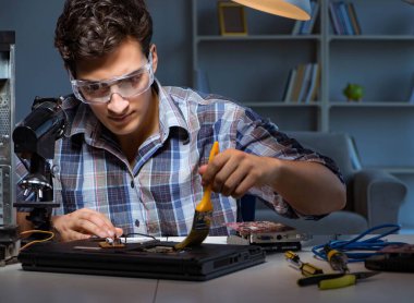 Bilgisayar tamircisi fırçayla toz temizliyor