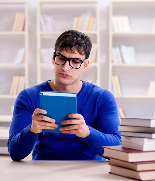 Mannelijke student bereidt zich voor op examens in universiteitsbibliotheek — Stockfoto