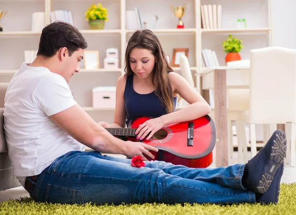 Pareja romántica tocando la guitarra en el suelo — Foto de Stock