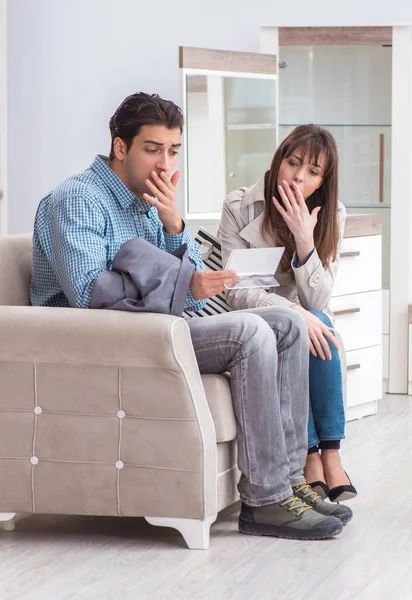 Young couple disappointed with price in furniture store