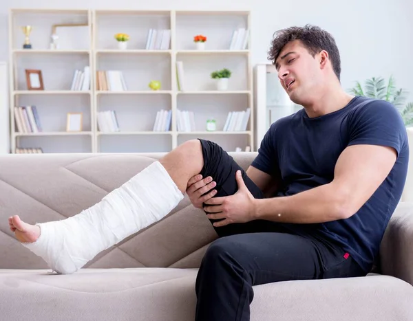 Hombre con la pierna rota recuperándose en casa —  Fotos de Stock