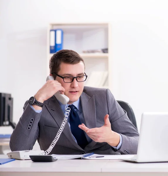 Работник бизнеса разговаривает по офисному телефону — стоковое фото