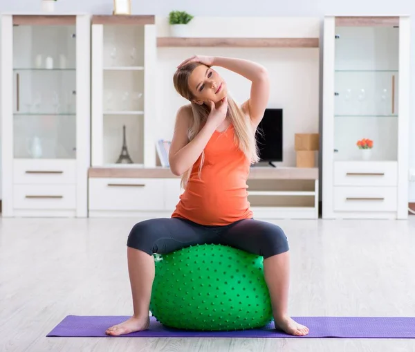 Jovem se preparando para o parto exercitando em casa — Fotografia de Stock