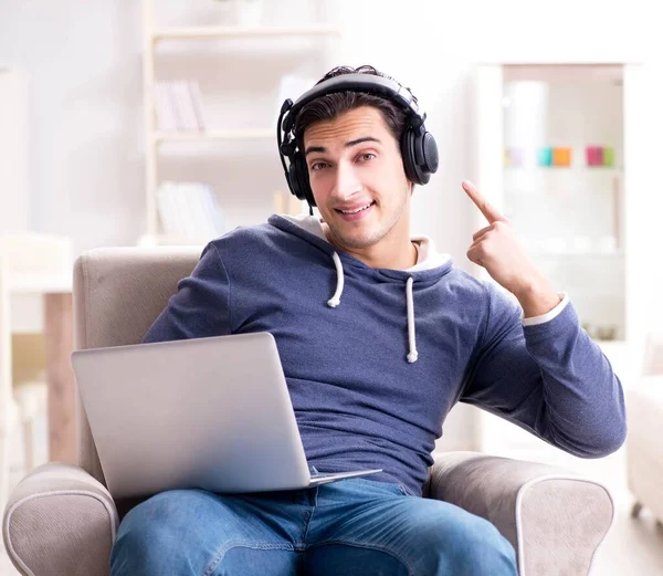 Jonge knappe man die naar muziek luistert met koptelefoon — Stockfoto