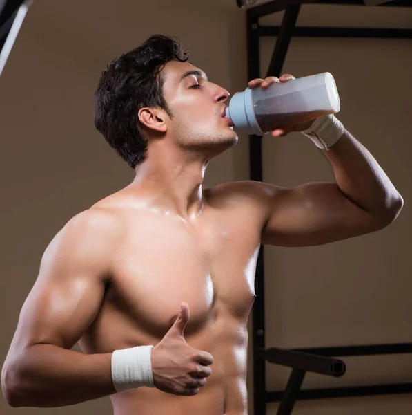 Homme avec des suppléments nutritifs dans la salle de sport — Photo