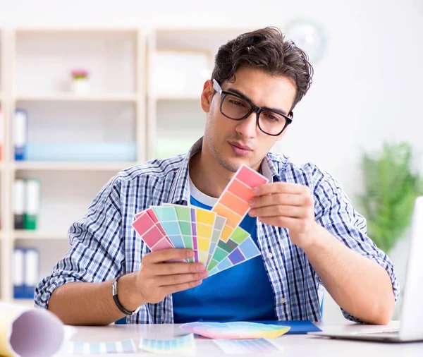 Joven diseñador trabajando en un nuevo proyecto y eligiendo colores —  Fotos de Stock