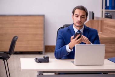 Ofisteki aşırı işten memnun olmayan genç bir erkek işçi.