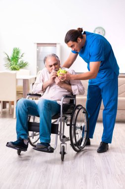 Tekerlekli sandalyedeki yaşlı adam ve genç kötü bakıcı.