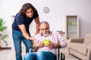 Tekerlekli sandalyedeki yaşlı adam ve genç kötü bakıcı.