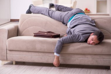 Yorgun genç işadamı işten sonra eve geliyor.