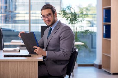 Ofiste çalışan genç bir erkek.