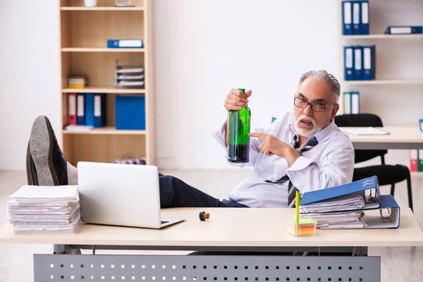 Un vieil employé boit de l'alcool au bureau — Photo