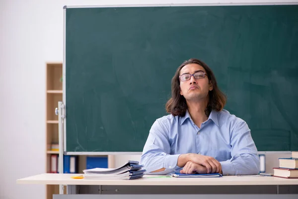 Jonge mannelijke leraar in de voorkant van groene boord — Stockfoto