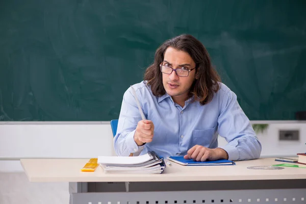 Jonge mannelijke leraar in de voorkant van groene boord — Stockfoto