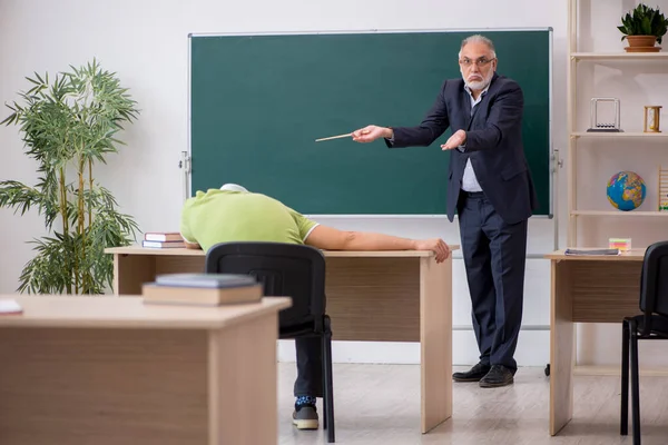 高齢の先生と男性怠惰な学生でザ教室 — ストック写真