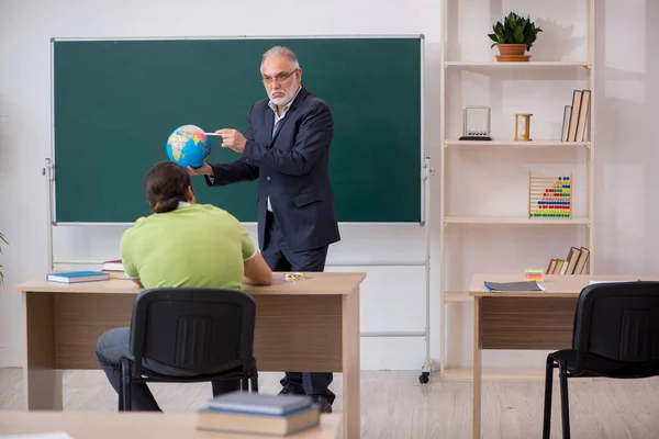 Leeftijd aardrijkskunde leraar en mannelijke student in de klas — Stockfoto